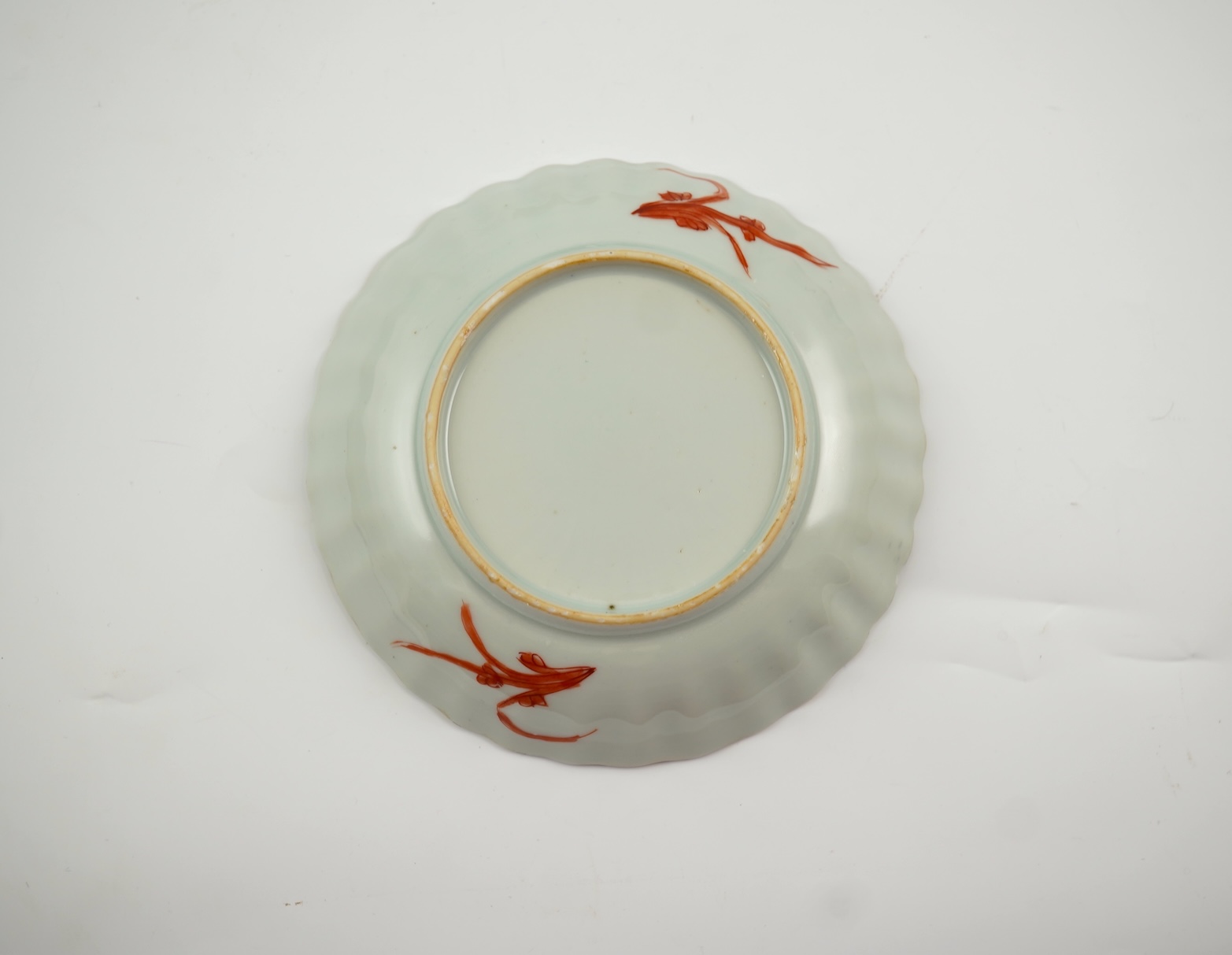 A Chinese rouge de fer tea bowl and saucer and a similar cup, Qianlong period